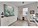 Chic home office with a sleek white desk, modern art, and built-in storage cabinets at 19165 Iron Topsail Isle, Land O Lakes, FL 34638