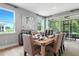 Elegant dining room with natural light, stylish decor, and sliding glass doors leading to outdoor seating at 9211 Players Dr, Weeki Wachee, FL 34613