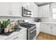 Stylish kitchen with stainless steel appliances, white cabinets, and modern finishes at 9211 Players Dr, Weeki Wachee, FL 34613