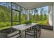 Screened lanai with dining table and wooded views, perfect for outdoor dining at 9211 Players Dr, Weeki Wachee, FL 34613