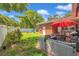 Private backyard with lush lawn, patio seating, hot tub, a white fence, and mature trees at 2601 Upton S St, Gulfport, FL 33711