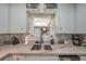 Close up of kitchen sink with granite countertops, subway tile, and modern faucet at 2601 Upton S St, Gulfport, FL 33711