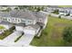 Aerial view of a two-story townhome featuring a brick-paved driveway, a two-car garage, and a well-kept lawn at 5367 Riverwalk Preserve Dr, New Port Richey, FL 34653