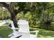 Adirondack chairs offer a relaxing view of the serene waterfront and lush landscaping at 5367 Riverwalk Preserve Dr, New Port Richey, FL 34653