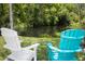 Adirondack chairs offer a relaxing view of the serene waterfront and lush landscaping at 5367 Riverwalk Preserve Dr, New Port Richey, FL 34653