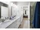 En-suite bathroom with double sinks, granite countertops, modern faucets, and a glass-enclosed shower with tiled walls at 5367 Riverwalk Preserve Dr, New Port Richey, FL 34653
