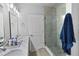 Modern bathroom features a double sink vanity, glass-enclosed shower with tile surround, and wood-look flooring at 5367 Riverwalk Preserve Dr, New Port Richey, FL 34653