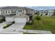 Two-story townhome showcasing an attached two-car garage, brick-paved driveway, and well-manicured lawn at 5367 Riverwalk Preserve Dr, New Port Richey, FL 34653
