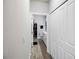 Hallway with wood floors leading to a walk-in closet and a bathroom with a toilet and vanity at 5367 Riverwalk Preserve Dr, New Port Richey, FL 34653