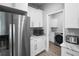 Kitchen area with stainless steel refrigerator and access to laundry room at 5367 Riverwalk Preserve Dr, New Port Richey, FL 34653