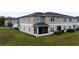 Exterior view of a two-story townhome featuring a screened-in porch and a well-maintained lawn at 5367 Riverwalk Preserve Dr, New Port Richey, FL 34653