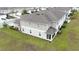 Back view of a two-story townhome with a screened-in patio, well-maintained lawn, and tidy landscaping at 5367 Riverwalk Preserve Dr, New Port Richey, FL 34653
