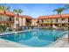 Community pool surrounded by palm trees and lounge chairs at 10365 Paradise Blvd # 21, Treasure Island, FL 33706