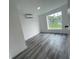 Bright bedroom featuring wood-look floors and a large window offering ample natural light at 4546 Ontario Dr, New Port Richey, FL 34652