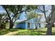 The exterior of this bright blue home features manicured landscaping, green lawn and mature trees at 4546 Ontario Dr, New Port Richey, FL 34652