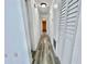 Bright hallway featuring wood-look tile flooring and white louvered closet doors at 4546 Ontario Dr, New Port Richey, FL 34652