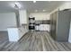 Open kitchen featuring granite countertops, stainless steel appliances, and grey wood-look tile flooring at 4546 Ontario Dr, New Port Richey, FL 34652