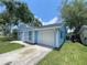 Light blue house with attached garage, set in a green lawn, with a blue sky backdrop at 4546 Ontario Dr, New Port Richey, FL 34652