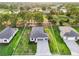 Aerial view of a one-story home with well-kept landscaping, a gray roof, and a gray brick driveway at 9127 Players Dr, Weeki Wachee, FL 34613