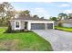 Beautiful single-story home with a gray brick driveway, stone accents, manicured lawn, and a two-car garage at 9127 Players Dr, Weeki Wachee, FL 34613