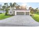 Beautiful single-story home with a gray brick driveway, stone accents, manicured lawn, and a two-car garage at 9127 Players Dr, Weeki Wachee, FL 34613