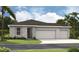New home featuring a three-car garage and stone veneer details on the facade at 9127 Players Dr, Weeki Wachee, FL 34613