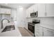 Beautiful kitchen with an island, tile floors, stainless steel appliances, and white cabinets at 9127 Players Dr, Weeki Wachee, FL 34613