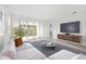 Bright living room with sliding glass doors, modern furniture, and sleek entertainment center at 9127 Players Dr, Weeki Wachee, FL 34613
