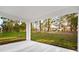 Covered patio area with lush green landscaping and a view of the surrounding trees at 9127 Players Dr, Weeki Wachee, FL 34613