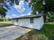 Charming single story home features a white exterior, a concrete driveway and beautiful green landscaping at 390 Hazel Cir, Punta Gorda, FL 33982