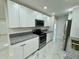 Bright kitchen features white cabinets, stainless steel appliances, and granite countertops at 390 Hazel Cir, Punta Gorda, FL 33982
