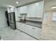 Open concept kitchen with marble tile floors, granite countertops and new stainless steel appliances at 390 Hazel Cir, Punta Gorda, FL 33982