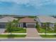 Aerial view of a home with a tile roof, lush landscaping, and a paver driveway at 14553 Eagle Branch Dr, Nokomis, FL 34275