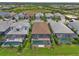 Aerial view showcasing the backyard pools of homes in a residential community with green spaces and tile roofs at 14553 Eagle Branch Dr, Nokomis, FL 34275