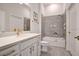 Modern bathroom with a white vanity, neutral tile, and a combined shower and tub with accessibility features at 14553 Eagle Branch Dr, Nokomis, FL 34275