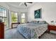 Serene bedroom featuring a ceiling fan, multiple windows, and soft gray carpeting at 14553 Eagle Branch Dr, Nokomis, FL 34275
