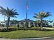 Attractive community center with an American flag and palm trees in a well-manicured lawn at 14553 Eagle Branch Dr, Nokomis, FL 34275