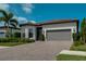 Beautiful single-story home with a paver driveway, a two-car garage, and lush landscaping at 14553 Eagle Branch Dr, Nokomis, FL 34275