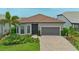 Charming single-story home featuring a tile roof, paved driveway, and lush landscaping at 14553 Eagle Branch Dr, Nokomis, FL 34275