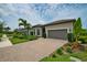 Beautiful home with a paver driveway, lush landscaping, two-car garage and tile roof at 14553 Eagle Branch Dr, Nokomis, FL 34275