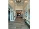Elegant hallway with paneled walls, hardwood floors, and designer lighting fixtures create a welcoming ambiance at 14553 Eagle Branch Dr, Nokomis, FL 34275