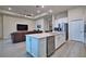 Open kitchen with white cabinets, stainless appliances and eat in island, open to living room at 14553 Eagle Branch Dr, Nokomis, FL 34275