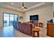 Bright living room featuring tile floors, coffered ceiling, leather furniture and sliding doors to the lanai at 14553 Eagle Branch Dr, Nokomis, FL 34275