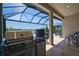 Outdoor patio with built-in grill, cooking space and covered seating overlooking a scenic pond and sunny skies at 14553 Eagle Branch Dr, Nokomis, FL 34275