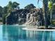 Inviting pool featuring a rock waterfall, creating a tranquil and luxurious atmosphere for relaxation at 14553 Eagle Branch Dr, Nokomis, FL 34275