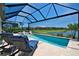 Relaxing screened-in pool with lounge chairs and an outdoor spa overlooking picturesque water and neighborhood views at 14553 Eagle Branch Dr, Nokomis, FL 34275
