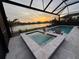 Relaxing screened-in pool and spa with a stunning sunset lake view at 14553 Eagle Branch Dr, Nokomis, FL 34275
