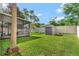 Well-maintained backyard with a screened-in patio, storage shed, and privacy fence at 6932 Gray Catbird Loop, Wesley Chapel, FL 33545