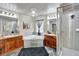 Bathroom featuring double sinks, a separate glass shower, and a corner tub at 6932 Gray Catbird Loop, Wesley Chapel, FL 33545
