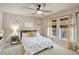 Comfortable bedroom with a ceiling fan and natural light from the windows at 6932 Gray Catbird Loop, Wesley Chapel, FL 33545